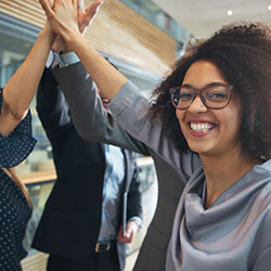 A trio of people giving each other high fives.