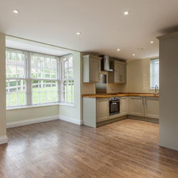 Inside a home that's vacant. The dining room and kitchen is empty and bare.