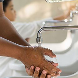 A man washing his hands at a bathroom sink.